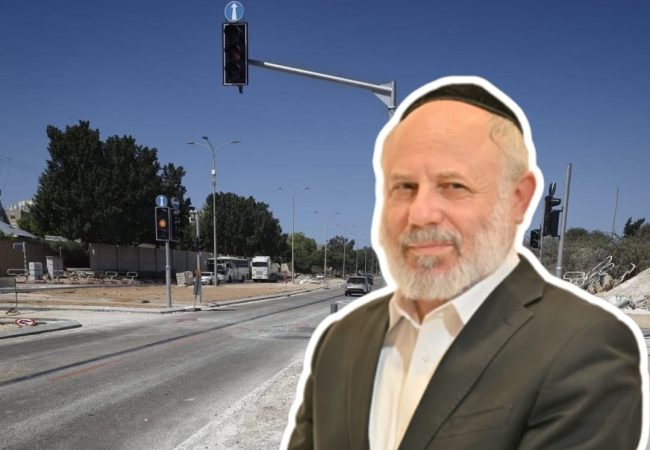 חבר המועצה עזרא שור על רקע הרמזורים שהוצבו בכניסה לבית העלמין